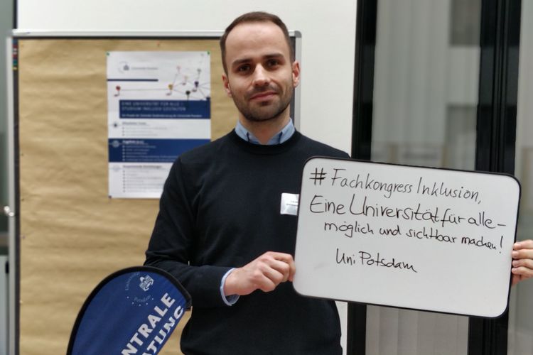 Hier im Foto zeigt ein Projektmitglied auf unserer Tafel seinen Schriftzug "#FachkongressInklusion, 'Eine Universität für alle' – möglich und sichtbar machen!"